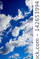 vertical view of dynamic clouds in a blue sky 142653994