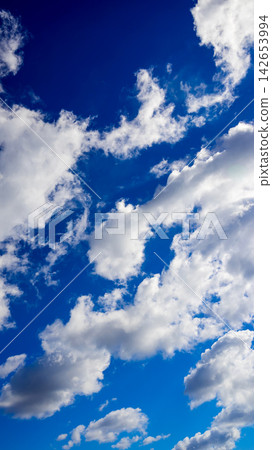 vertical view of dynamic clouds in a blue sky vertical view of dynamic clouds in a blue sky 142653994