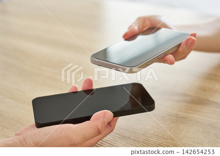 將兩部智慧型手機拉近 將兩部智慧型手機拉近 142654253