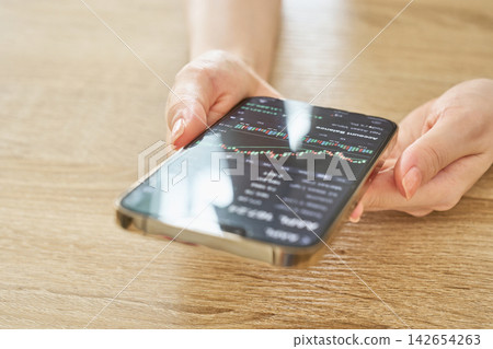 A woman's hands as she checks her asset balance. A woman's hands as she checks her asset balance. 142654263