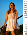 Slavic Woman in White Dress on Railing 142654329