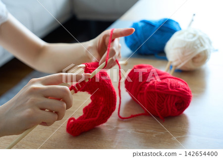 一雙女人的手正在用毛線編織。 142654400