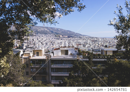 Athens, Attica, Greece, beautiful panoramic view of Athens cityscape, with The Parthenon, mountains, sea and scenery beyond the city, seen from Mount Lycabettus Hill observation deck in a sunny day Athens, Attica, Greece, beautiful panoramic view of Athens cityscape, with The Parthenon, mountains, sea and scenery beyond the city, seen from Mount Lycabettus Hill observation deck in a sunny day 142654781
