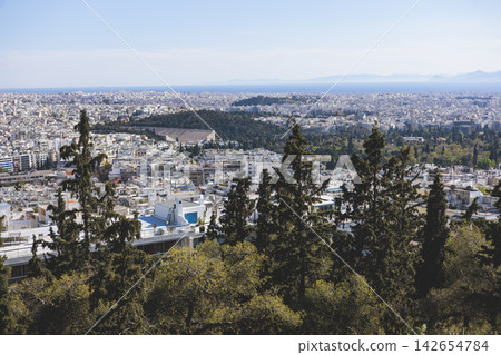 Athens, Attica, Greece, beautiful panoramic view of Athens cityscape, with The Parthenon, mountains, sea and scenery beyond the city, seen from Mount Lycabettus Hill observation deck in a sunny day 142654784