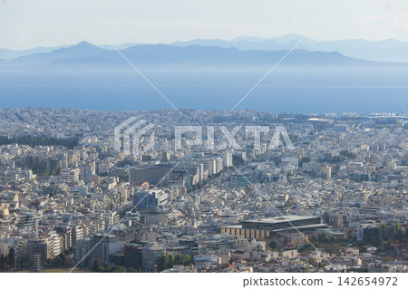 Athens, Attica, Greece, beautiful panoramic view of Athens cityscape, with The Parthenon, mountains, sea and scenery beyond the city, seen from Mount Lycabettus Hill observation deck in a sunny day Athens, Attica, Greece, beautiful panoramic view of Athens cityscape, with The Parthenon, mountains, sea and scenery beyond the city, seen from Mount Lycabettus Hill observation deck in a sunny day 142654972