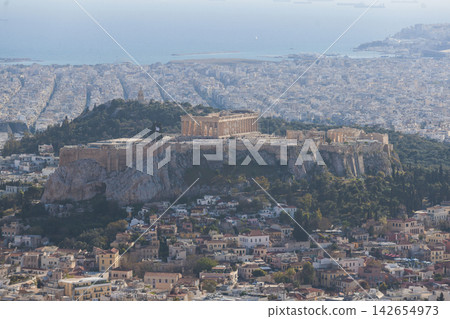 Athens, Attica, Greece, beautiful panoramic view of Athens cityscape, with The Parthenon, mountains, sea and scenery beyond the city, seen from Mount Lycabettus Hill observation deck in a sunny day Athens, Attica, Greece, beautiful panoramic view of Athens cityscape, with The Parthenon, mountains, sea and scenery beyond the city, seen from Mount Lycabettus Hill observation deck in a sunny day 142654973