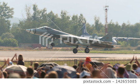 A Russian Air Force Sukhoi Su-57 stealth fighter jet landing, accompanied by spectators. A Russian Air Force Sukhoi Su-57 stealth fighter jet landing, accompanied by spectators. 142655085