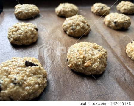 oatmeal cookie sheets laid out in rows on a baking sheet before baking oatmeal cookie sheets laid out in rows on a baking sheet before baking 142655178