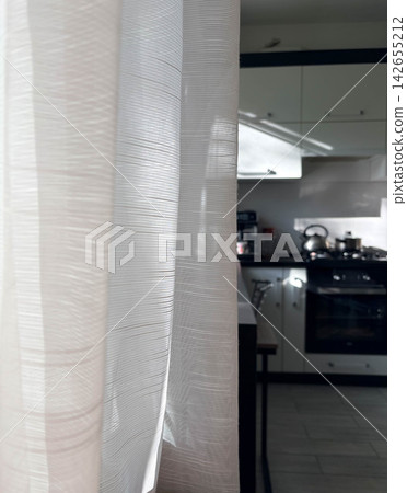 A vertical photo of a cozy home interior with a visible kitchen A vertical photo of a cozy home interior with a visible kitchen 142655212