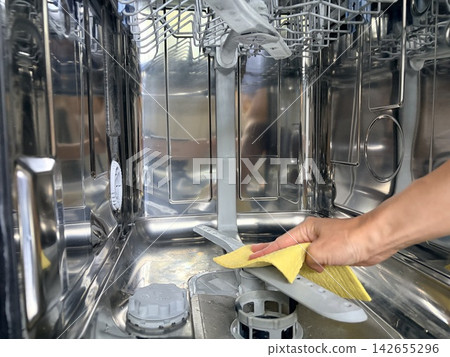 Caring for kitchen appliances and cleaning the dishwasher. A close-up view inside a modern, stainless steel dishwasher. 142655296