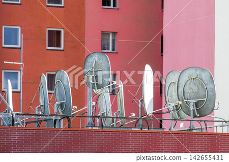 Multiple Satellite Dishes Installed on Rooftop of Residential Apartment Building for TV Reception Multiple Satellite Dishes Installed on Rooftop of Residential Apartment Building for TV Reception 142655431