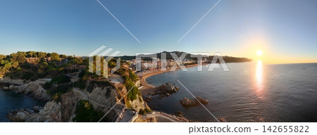 Aerial view taken from a drone of the coast of Lloret de Mar, Costa Brava, Spain, early in the morning at sunrise - the sea, beach and coastal hotels Aerial view taken from a drone of the coast of Lloret de Mar, Costa Brava, Spain, early in the morning at sunrise - the sea, beach and coastal hotels 142655822