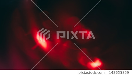 Bokeh red light. Lens glare. Defocused neon color optical vibrant gleam illuminated flash on abstract visual dark black art background. 142655869