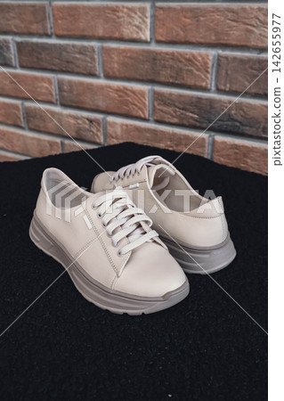 Fresh beige leather sneakers without brand marks displayed. For design templates online shops and sustainability-themed marketing. Clean blank sneakers Fresh beige leather sneakers without brand marks displayed. For design templates online shops and sustainability-themed marketing. Clean blank sneakers 142655977