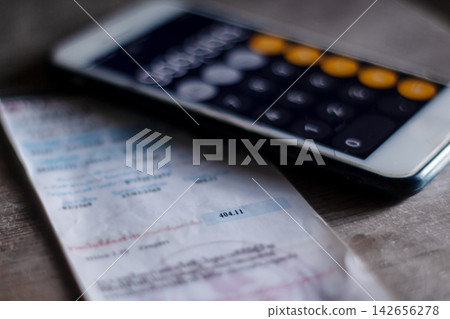 Electricity bill with expense records showing household costs income planning and financial balance. Electricity bill with expense records showing household costs income planning and financial balance. 142656278