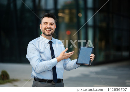 Happy businessman presenting digital tablet for business success Happy businessman presenting digital tablet for business success 142656707