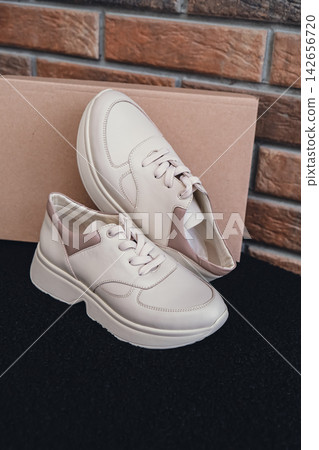 Fresh beige leather sneakers without brand marks displayed. For design templates online shops and sustainability-themed marketing. Clean blank sneakers Fresh beige leather sneakers without brand marks displayed. For design templates online shops and sustainability-themed marketing. Clean blank sneakers 142656720