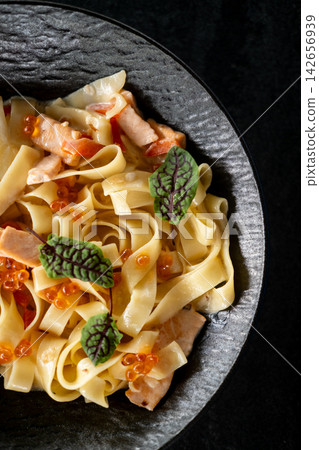 Macaroni lunch. Served meal. Gourmet food with salmon red caviar in cream sauce. Delicious spaghetti garnished with fresh chard leaves. Macaroni lunch. Served meal. Gourmet food with salmon red caviar in cream sauce. Delicious spaghetti garnished with fresh chard leaves. 142656939