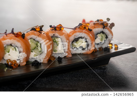 Sushi platter. Philadelphia set. Appetizing salmon roll row garnished with caviar micro sprouts. Asian menu restaurant gourmet meal. Sushi platter. Philadelphia set. Appetizing salmon roll row garnished with caviar micro sprouts. Asian menu restaurant gourmet meal. 142656965