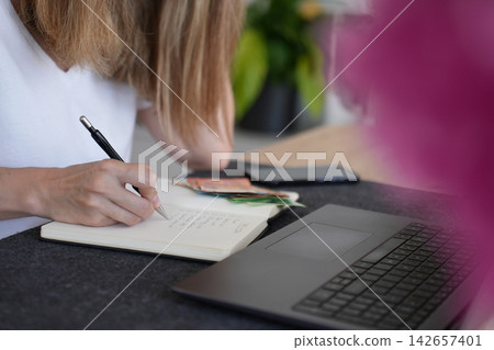 Woman calculating expenses and planning budget at home Woman calculating expenses and planning budget at home 142657401