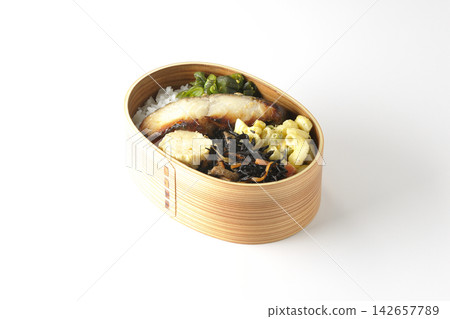 A bento box of grilled silver cod marinated in Saikyo miso, photographed against a white background. A bento box of grilled silver cod marinated in Saikyo miso, photographed against a white background. 142657789