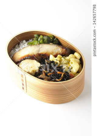 A bento box of grilled silver cod marinated in Saikyo miso, photographed against a white background. A bento box of grilled silver cod marinated in Saikyo miso, photographed against a white background. 142657798