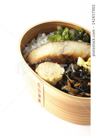 A bento box of grilled silver cod marinated in Saikyo miso, photographed against a white background. A bento box of grilled silver cod marinated in Saikyo miso, photographed against a white background. 142657802