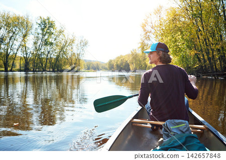 Man, canoeing and lake rowing in nature for morning adventure or exercise, exploring or island. Male person, back and Colorado traveling for outdoor hobby with boat at camp site, forest or nature Man, canoeing and lake rowing in nature for morning adventure or exercise, exploring or island. Male person, back and Colorado traveling for outdoor hobby with boat at camp site, forest or nature 142657848