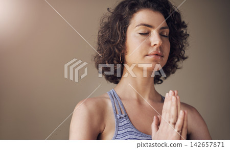 Woman, namaste and peace for meditation with yoga for holistic wellness, mental health or healing in studio. Person, yogi with prayer or hands for stress relief or zen on brown background with mockup Woman, namaste and peace for meditation with yoga for holistic wellness, mental health or healing in studio. Person, yogi with prayer or hands for stress relief or zen on brown background with mockup 142657871