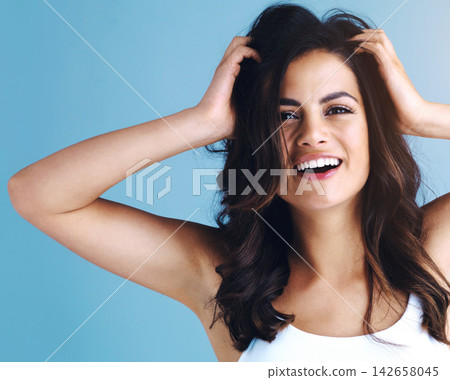 Portrait, hair care and beauty of happy woman for glow, health or wellness isolated on blue studio background. Face, hairstyle and laughing model in makeup cosmetics at hairdresser salon for shine Portrait, hair care and beauty of happy woman for glow, health or wellness isolated on blue studio background. Face, hairstyle and laughing model in makeup cosmetics at hairdresser salon for shine 142658045