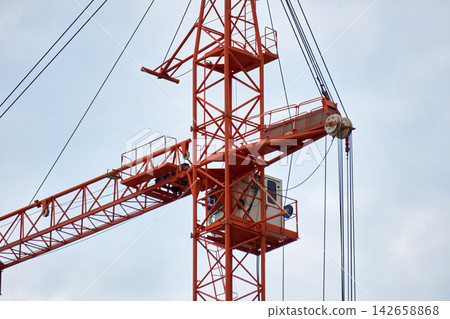 Close Up View of Orange Tower Crane Cabin and Top Pulley Mechanism Close Up View of Orange Tower Crane Cabin and Top Pulley Mechanism 142658868