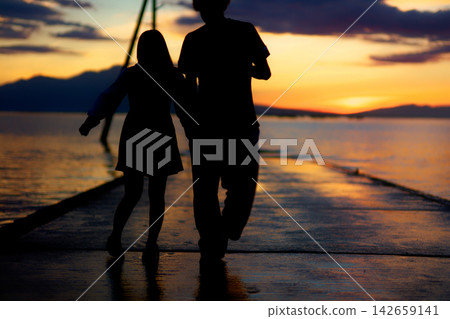 Evening view of the Osabeta Seashore Road | Summer scene of the setting sun over the Ariake Sea and a happy couple Evening view of the Osabeta Seashore Road | Summer scene of the setting sun over the Ariake Sea and a happy couple 142659141
