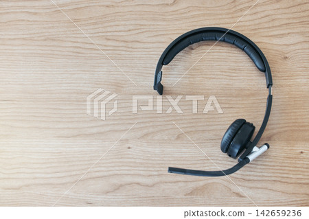 Wood background, headset and contact in call center for help desk, customer service or telemarketing. Tech support, table and headphones for communication, crm or tools for online consulting business 142659236