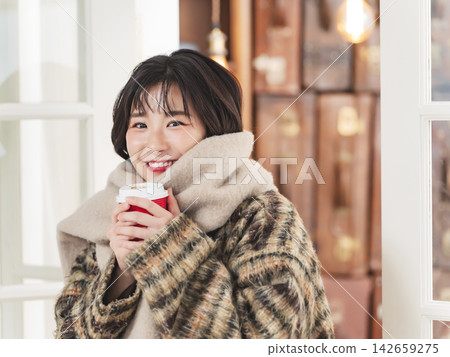 一位女士圍著圍巾。冬裝、秋裝、寒冷、咖啡、禦寒、外套、季節、時尚、溫暖、咖啡館 一位女士圍著圍巾。冬裝、秋裝、寒冷、咖啡、禦寒、外套、季節、時尚、溫暖、咖啡館 142659275