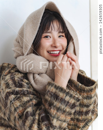 A woman wearing a scarf. Winter clothes, autumn clothes, cold, protection from the cold, coat, season, fashion, warm, cozy. 142659305