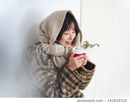 A woman wearing a scarf. Winter clothes, autumn clothes, cold, coffee, protection from the cold, coat, season, fashion, warm, cafe A woman wearing a scarf. Winter clothes, autumn clothes, cold, coffee, protection from the cold, coat, season, fashion, warm, cafe 142659320