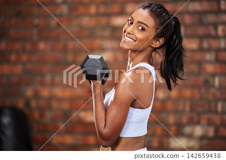 Indian girl, portrait and dumbbell for fitness at gym, bicep and training for muscle growth. Female person, confident and bodybuilder for weight lifting, strong body and workout for power or health Indian girl, portrait and dumbbell for fitness at gym, bicep and training for muscle growth. Female person, confident and bodybuilder for weight lifting, strong body and workout for power or health 142659438