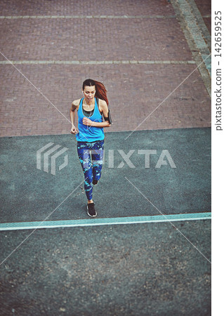Woman, exercise and running in street, above and training for fitness, health and speed in city. Girl, person or runner with earphones, phone and audio streaming subscription in road for workout Woman, exercise and running in street, above and training for fitness, health and speed in city. Girl, person or runner with earphones, phone and audio streaming subscription in road for workout 142659525