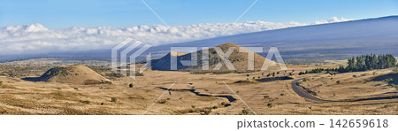 Desert, banner and landscape of mountains in nature, countryside or journey to inactive volcano in Hawaii. Hill, road and travel to bush in valley with grass, plants and clouds on horizon in blue sky Desert, banner and landscape of mountains in nature, countryside or journey to inactive volcano in Hawaii. Hill, road and travel to bush in valley with grass, plants and clouds on horizon in blue sky 142659618