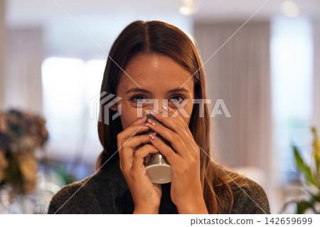 Customer, portrait and woman drinking coffee in cafe for beverage, break or caffeine at start of day. Face, hands and mug with happy consumer in small business restaurant for fresh, warm refreshment Customer, portrait and woman drinking coffee in cafe for beverage, break or caffeine at start of day. Face, hands and mug with happy consumer in small business restaurant for fresh, warm refreshment 142659699