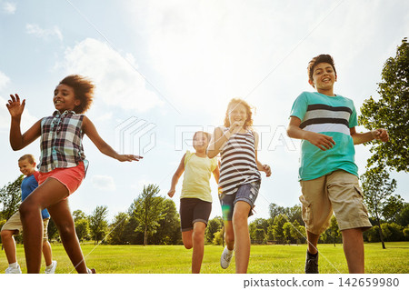 Happy friends, diversity and running with children in nature for fun, playful day or summer at park. Group of excited kids or youth enjoying sunny outdoor holiday or weekend on grass field together Happy friends, diversity and running with children in nature for fun, playful day or summer at park. Group of excited kids or youth enjoying sunny outdoor holiday or weekend on grass field together 142659980