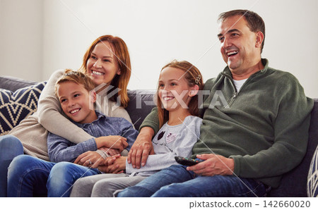 Happy family, couple and children together watching tv on sofa, couch and relax at home in living room. Television, movie and people in house or apartment for streaming comedy, video and broadcast Happy family, couple and children together watching tv on sofa, couch and relax at home in living room. Television, movie and people in house or apartment for streaming comedy, video and broadcast 142660020