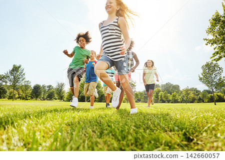Happy children, playing and running with friends in nature for fun, playful day or sunshine at park. Diversity or group of excited kids or youth enjoying sunny outdoor holiday on grass field together Happy children, playing and running with friends in nature for fun, playful day or sunshine at park. Diversity or group of excited kids or youth enjoying sunny outdoor holiday on grass field together 142660057