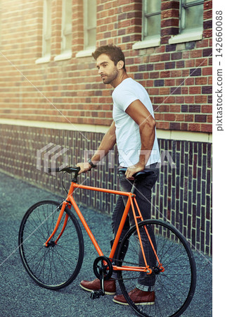 Walking, bicycle and man by brick wall in city for sightseeing on vacation, holiday or adventure. Outdoor, travel and male person with bike for carbon footprint in town on weekend trip in Netherlands Walking, bicycle and man by brick wall in city for sightseeing on vacation, holiday or adventure. Outdoor, travel and male person with bike for carbon footprint in town on weekend trip in Netherlands 142660088