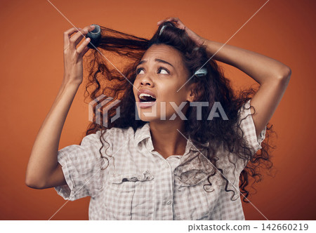 Woman, hair roller and stuck or disappointed with damage in studio on brown background with shock, treatment and bad results. Female person, isolated and upset at style with stress and frustrated Woman, hair roller and stuck or disappointed with damage in studio on brown background with shock, treatment and bad results. Female person, isolated and upset at style with stress and frustrated 142660219