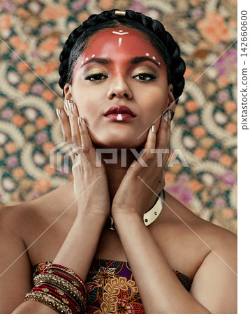 Africa, hands and portrait for culture with black woman in studio on wallpaper background for tradition. Beauty, face and fashion with confident young tribal person in makeup for custom or ritual Africa, hands and portrait for culture with black woman in studio on wallpaper background for tradition. Beauty, face and fashion with confident young tribal person in makeup for custom or ritual 142660600