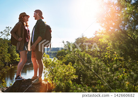 Nature, hiking and couple on rocks at lake on adventure holiday in mountain with trees, sun, and water. Trekking, man and woman on travel vacation together at river, forest or outdoor climbing park Nature, hiking and couple on rocks at lake on adventure holiday in mountain with trees, sun, and water. Trekking, man and woman on travel vacation together at river, forest or outdoor climbing park 142660682
