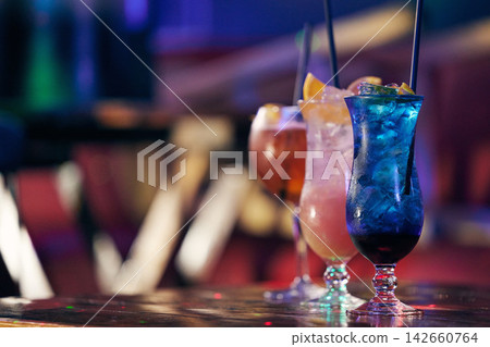 Cocktails, alcohol beverage and fruit for drink at table in a nightclub for party, event or social gathering. Mixology, mocktail and ice in glass with straw for refreshments to celebrate at pub Cocktails, alcohol beverage and fruit for drink at table in a nightclub for party, event or social gathering. Mixology, mocktail and ice in glass with straw for refreshments to celebrate at pub 142660764