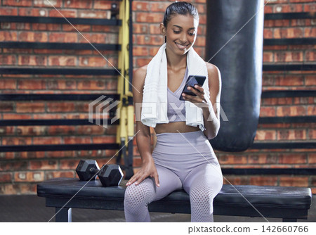 Happy woman, fitness and break with phone at gym for browsing or online search on workout or exercise. Female person with smile on mobile smartphone for training tips, news or app at health club Happy woman, fitness and break with phone at gym for browsing or online search on workout or exercise. Female person with smile on mobile smartphone for training tips, news or app at health club 142660766