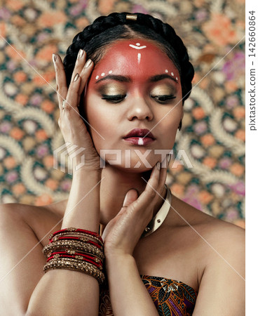 Pride, culture and girl in makeup, face and traditional in clothes or attire, serious and respect. Pattern, background and art for religion, indigenous and person with paint, red and color of tribe Pride, culture and girl in makeup, face and traditional in clothes or attire, serious and respect. Pattern, background and art for religion, indigenous and person with paint, red and color of tribe 142660864
